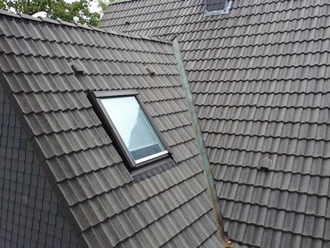 Frisch beschichtetes dunkles Dach mit Dachfenster